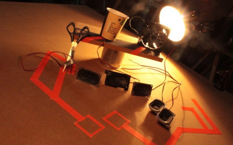 Verschiedene Lautsprecherboxen werden von einer Schreibtischlampe beleuchtet.