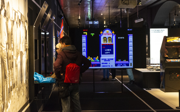 Two people stand in front of a screen in the exhibition room »zkm_gameplay«.